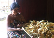 Korbflechterin im Longhouse auf Borneo